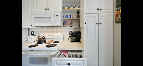 a small kitchen with white appliances and white cabinets