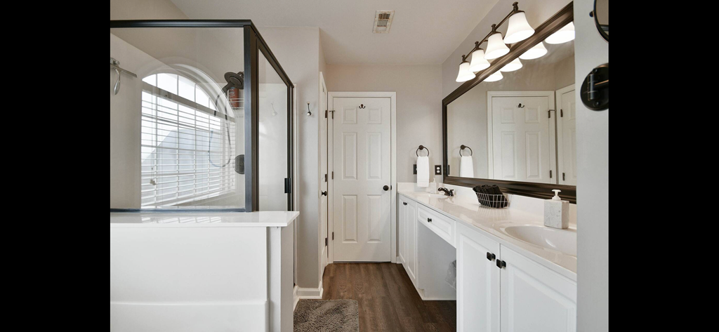 a bathroom with white cabinets and a sink and a mirror