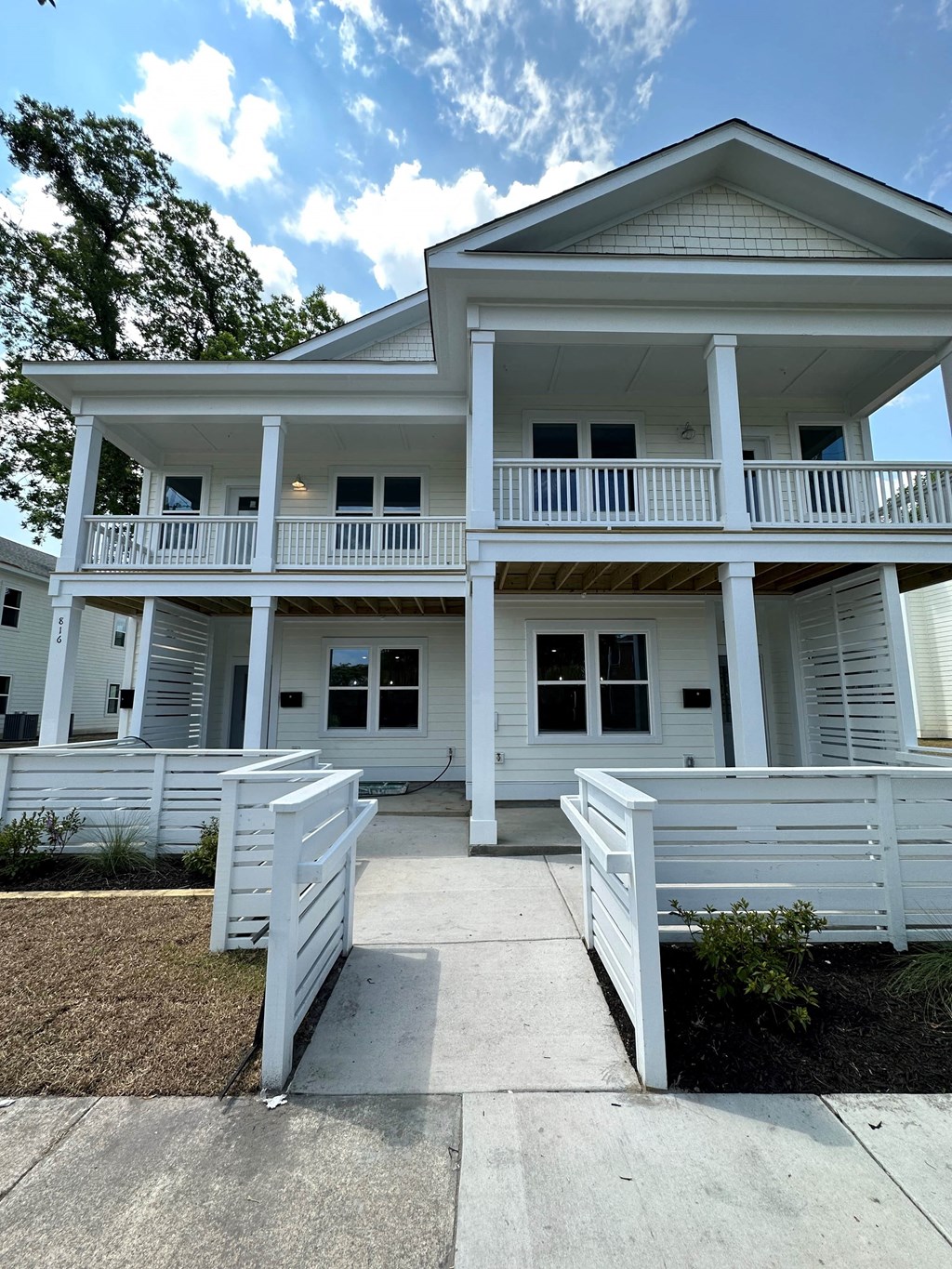 a white house with a porch and white benches