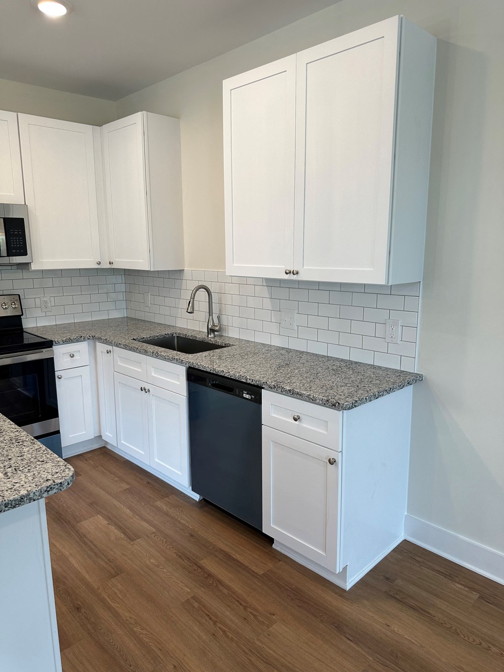 a kitchen with white cabinets and a sink and a counter top