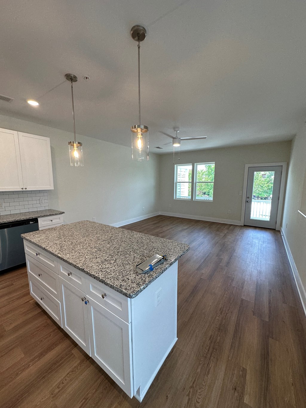 a kitchen and living room with white cabinets and a counter top
