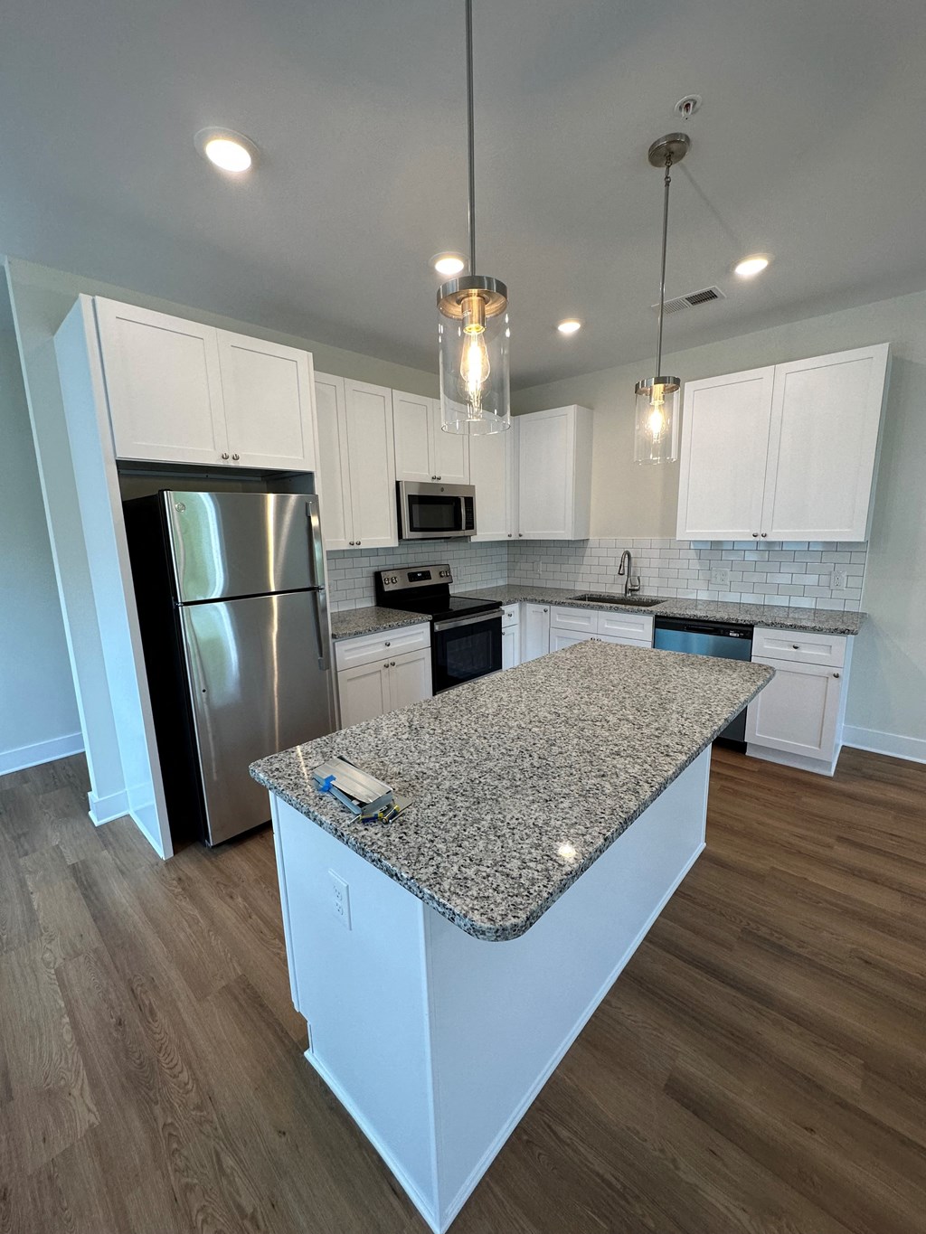 a kitchen with white cabinets and a granite counter top