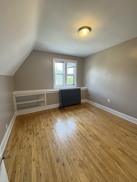 A room with wooden flooring and a window.