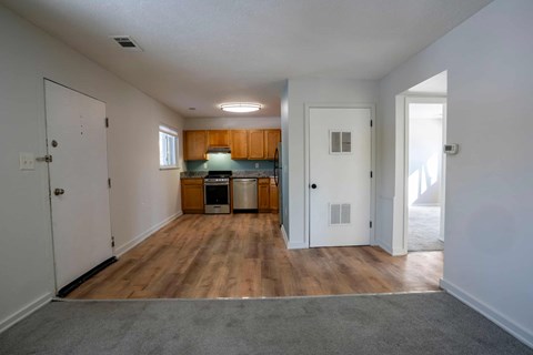 A kitchen area with wooden floors and white walls.