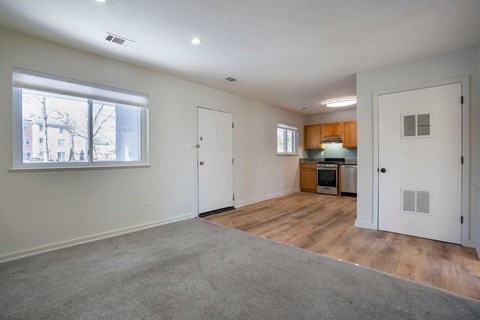 A room with a window, a door, and a kitchenette.