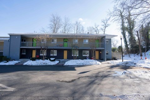 A grey building with green doors and windows.