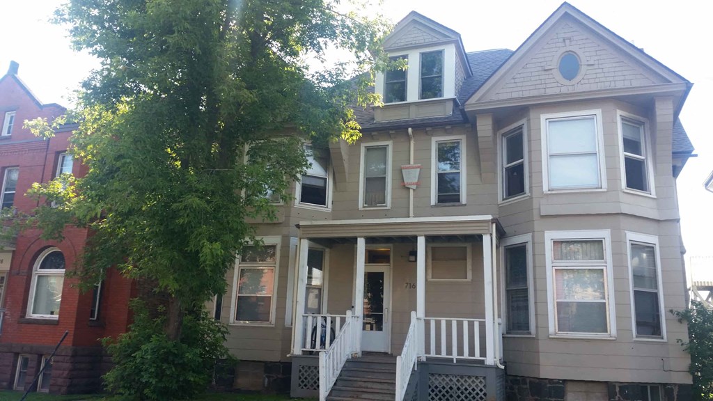 the front of a house with a tree in front of it