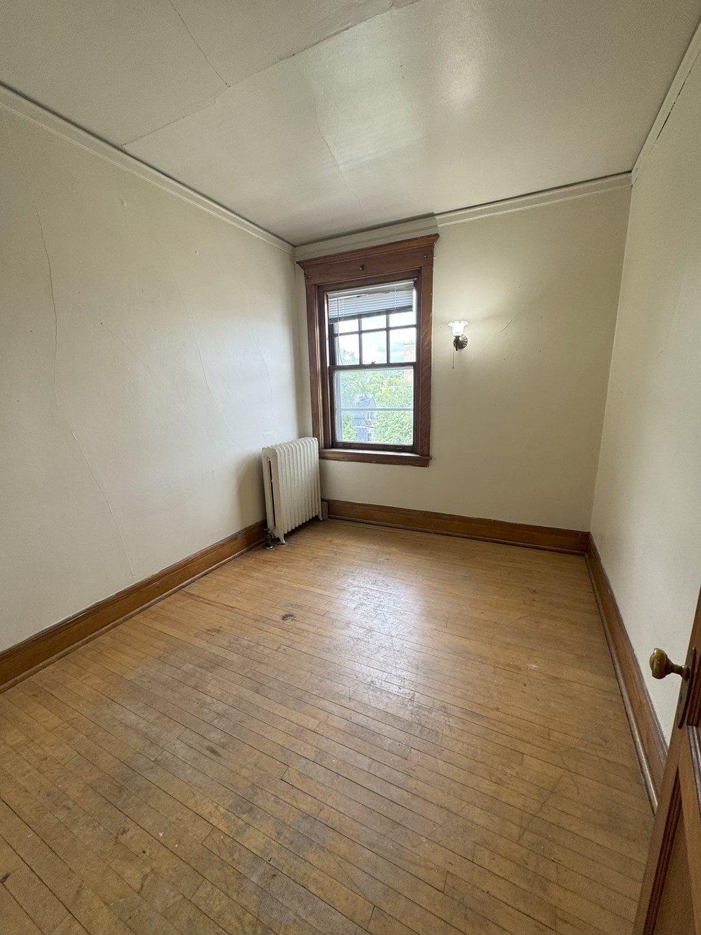 A room with wooden floors and a window.