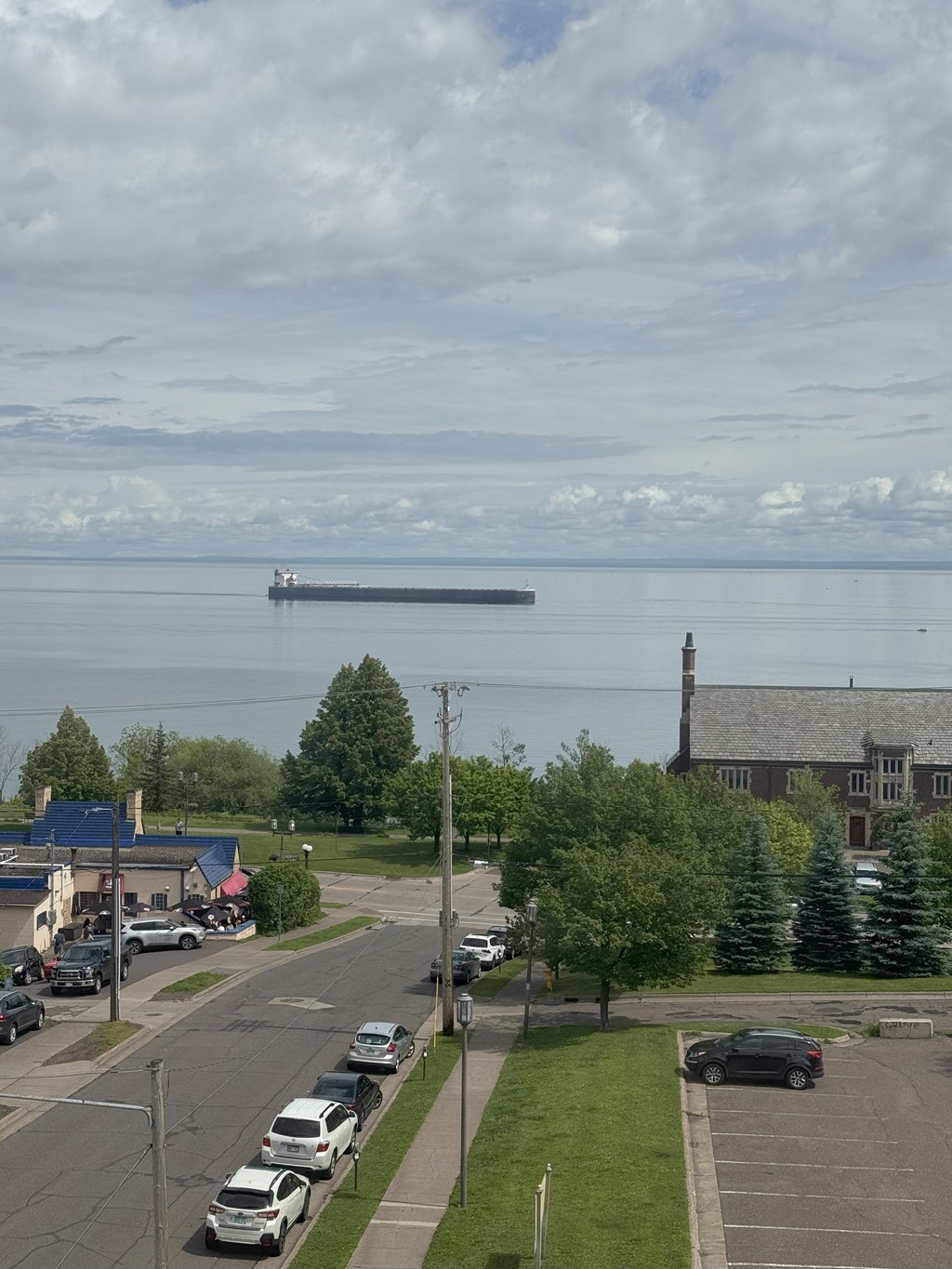 A view of a parking lot with cars and a church in the background.