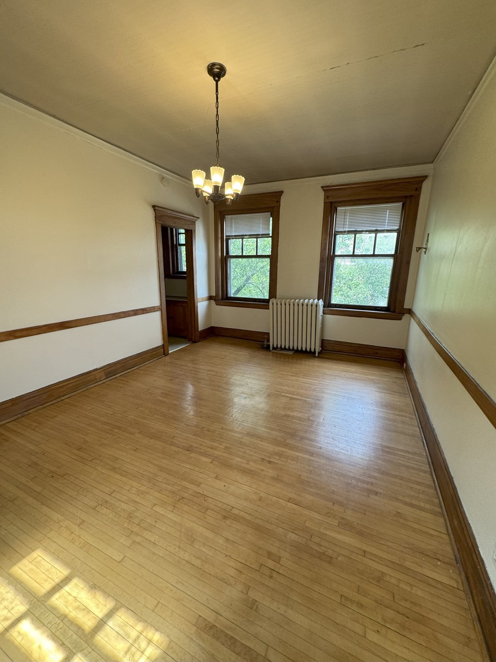 A room with wooden floors and a chandelier.