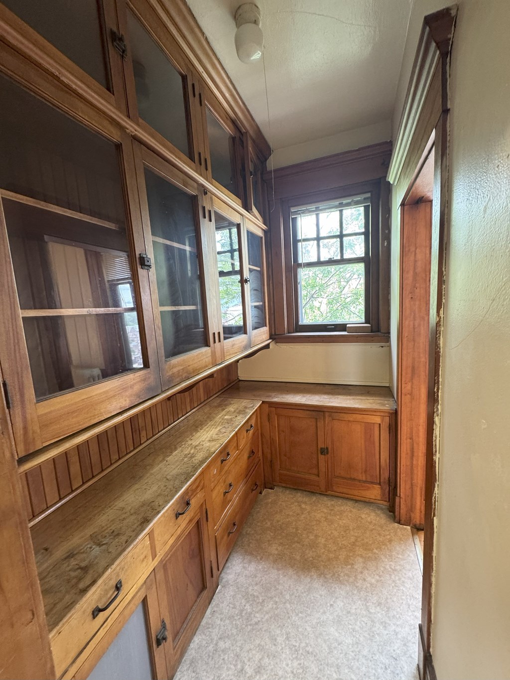 A kitchen with wooden cabinets and a window.