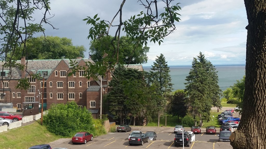 A parking lot with cars and a building in the background.