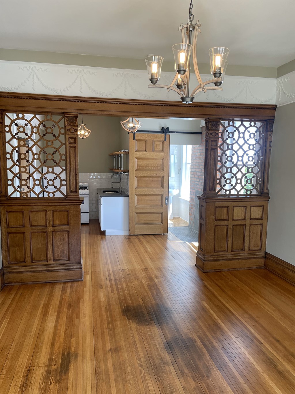 A room with wooden floors and a chandelier.