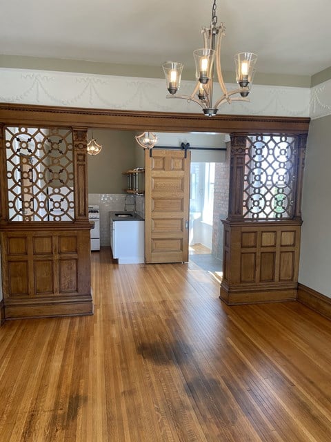 A room with wooden floors and a chandelier.