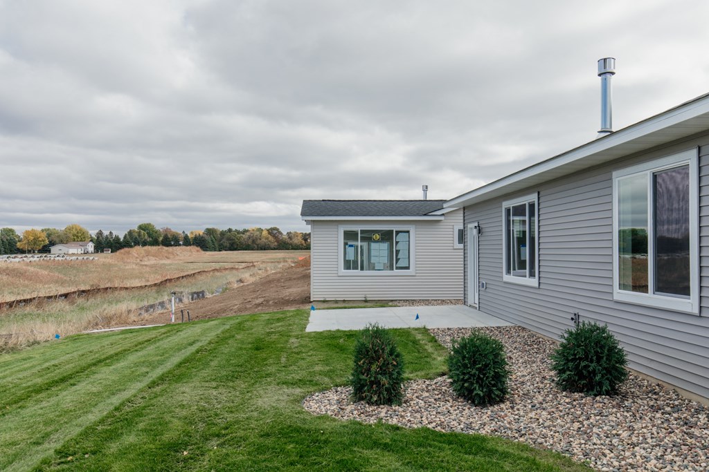a house with a yard and a field in the background