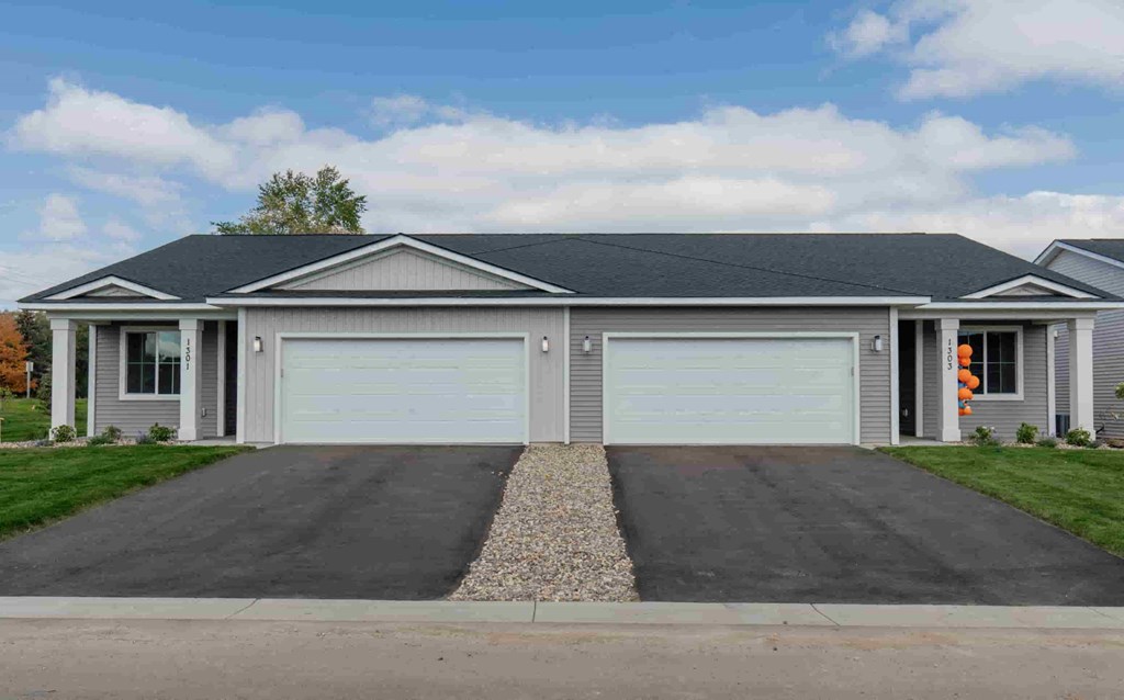a single story home with two garage doors and a driveway