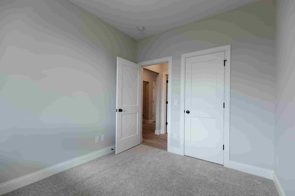 a bedroom with two closets and a door to a hallway