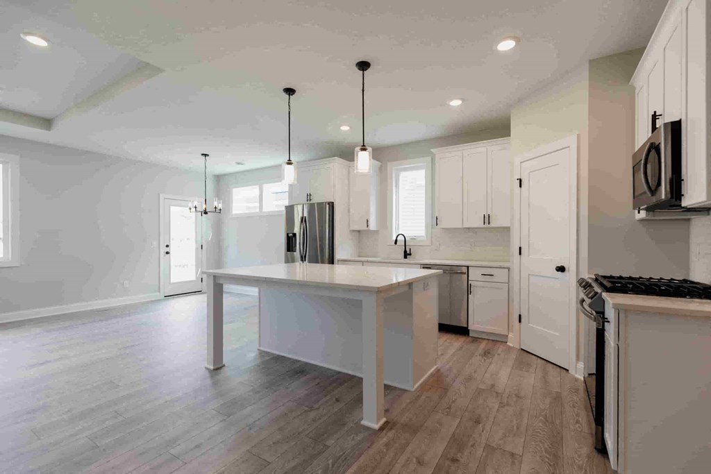 a large white kitchen with an island in the middle