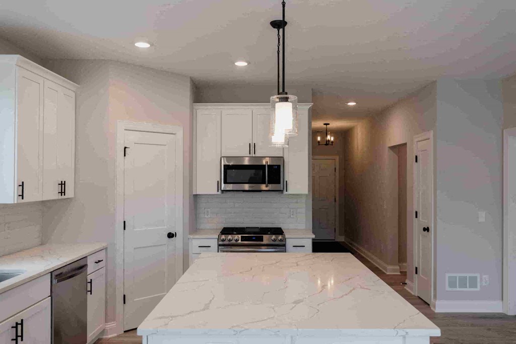 a large kitchen with white cabinets and a white counter top