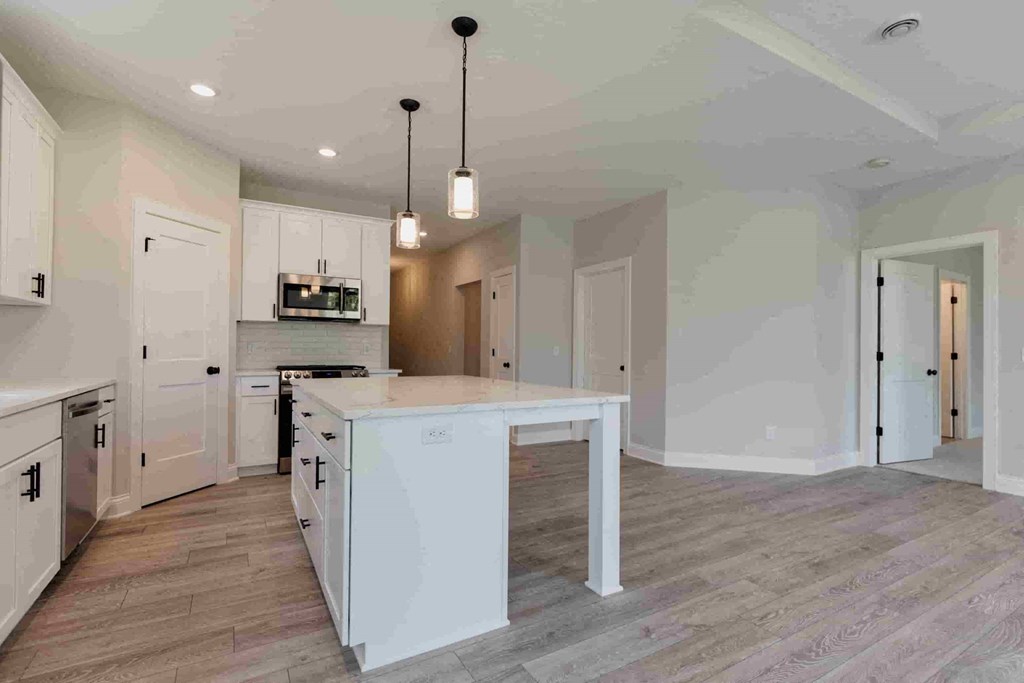 a large white kitchen with an island in the middle