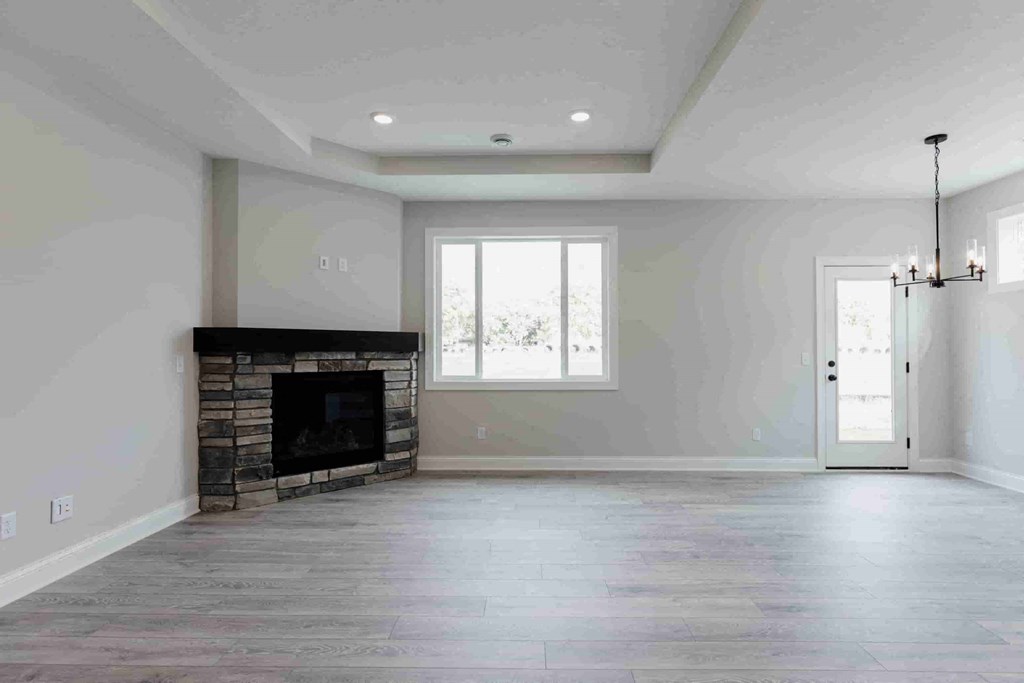 an empty living room with a fireplace and a door