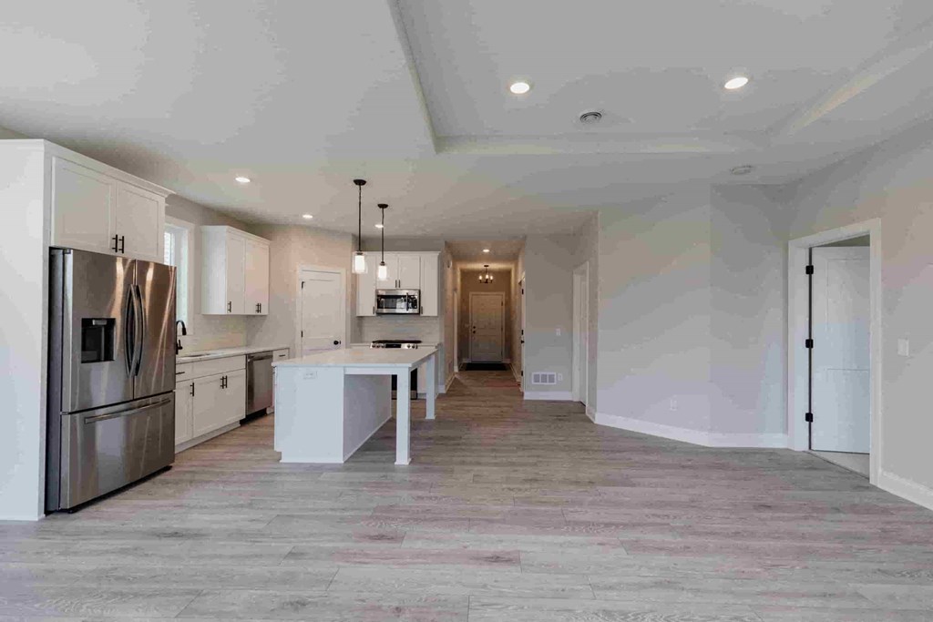 a large white kitchen with stainless steel appliances and white cabinets