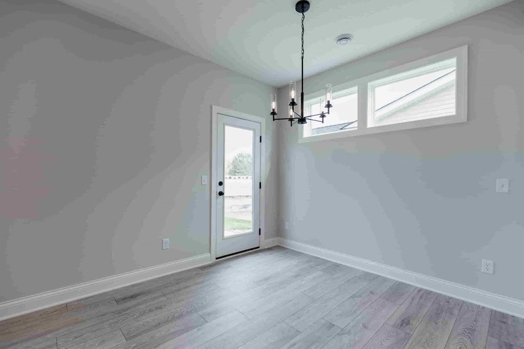 an empty room with a door and a chandelier