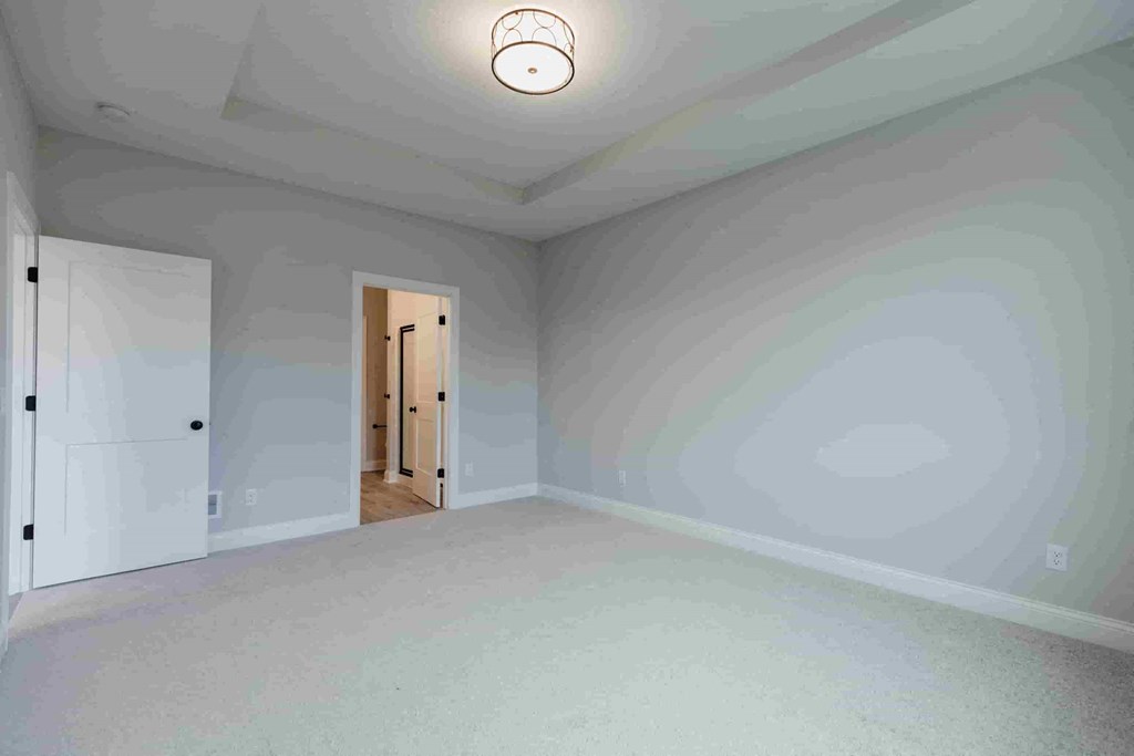 an empty living room with white walls and a ceiling light