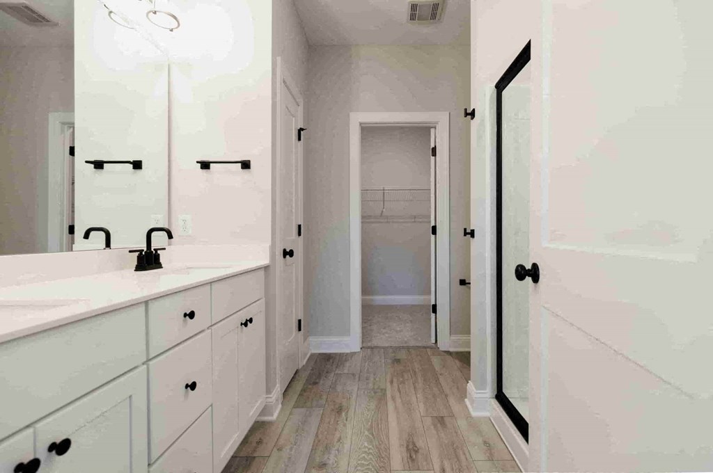 a bathroom with white cabinets and a sink and a mirror