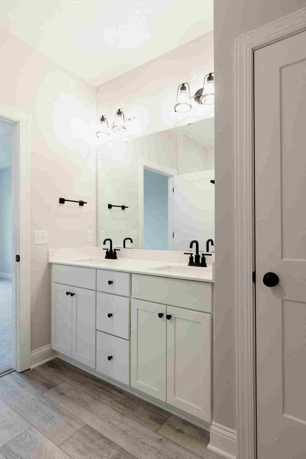 a bathroom with white cabinets and a sink and a mirror