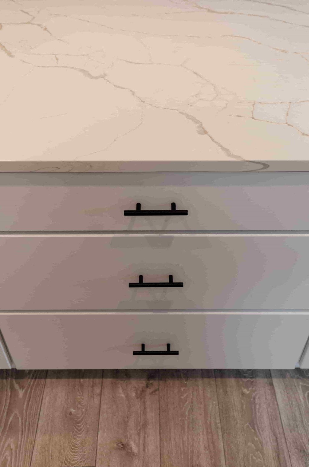 a close up of three drawers of a white counter top