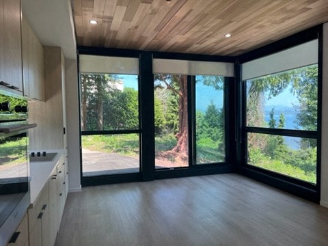 A modern kitchen with a view of the forest outside.