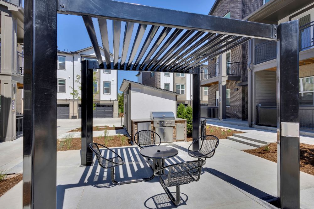 Outdoor seating, awning and grill in the courtyard of The Allyson Townhomes