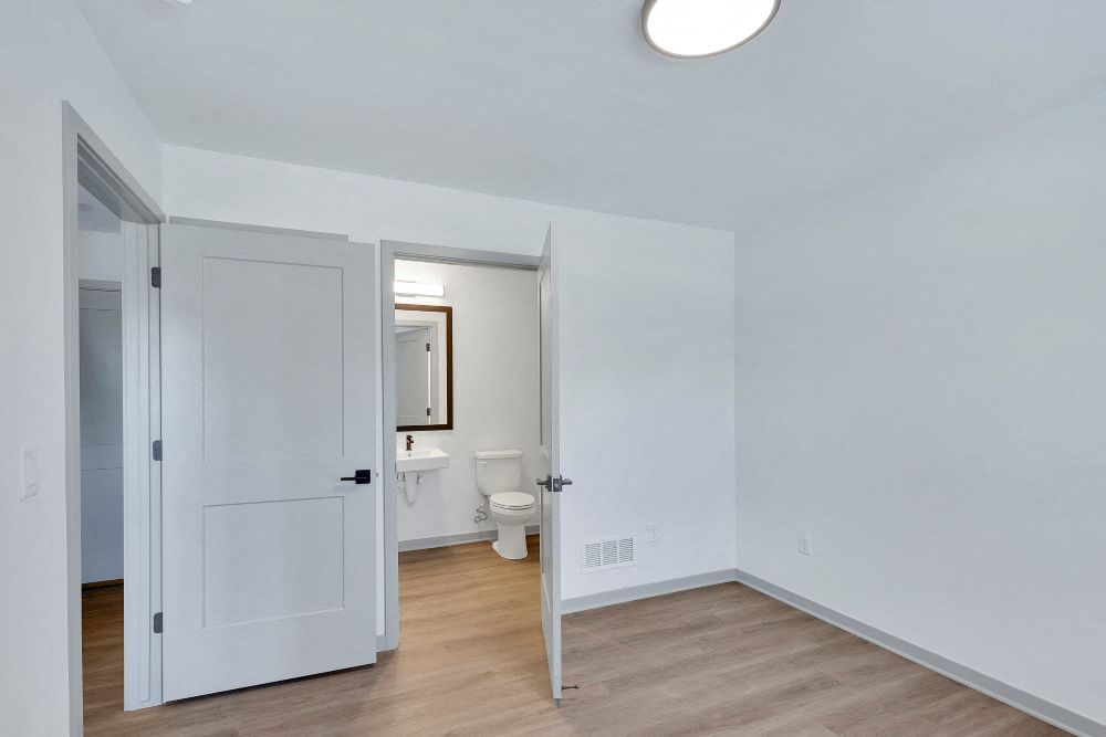 View from inside first floor bedroom with vinyl floor and full bath