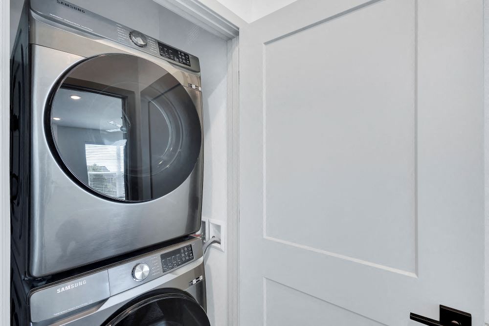 View inside the laundry closet with stacked full sized washer and dryer