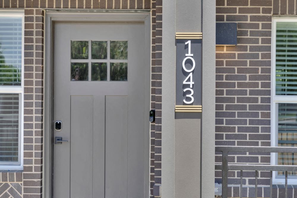 View of townhome front door with video doorbell and keyless door lock