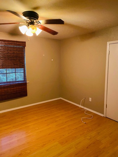 a living room with wood floors and a ceiling fan
