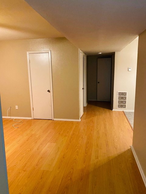 a living room and hallway with wood floors and a closet