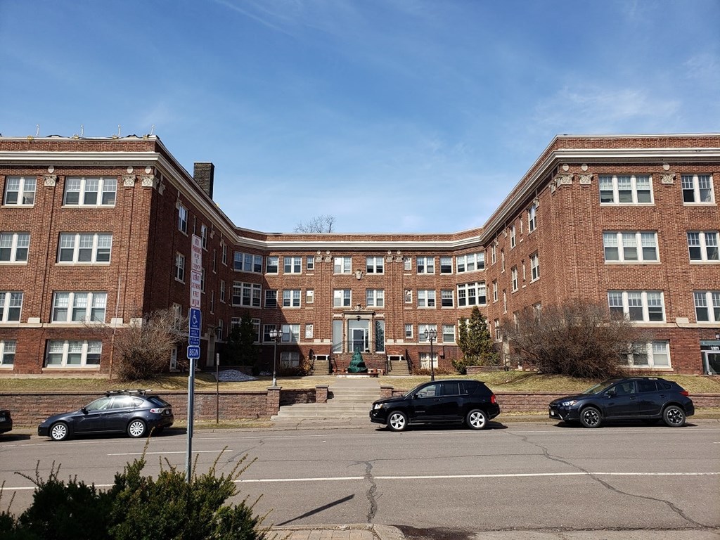 a large brick building with cars parked in front of it