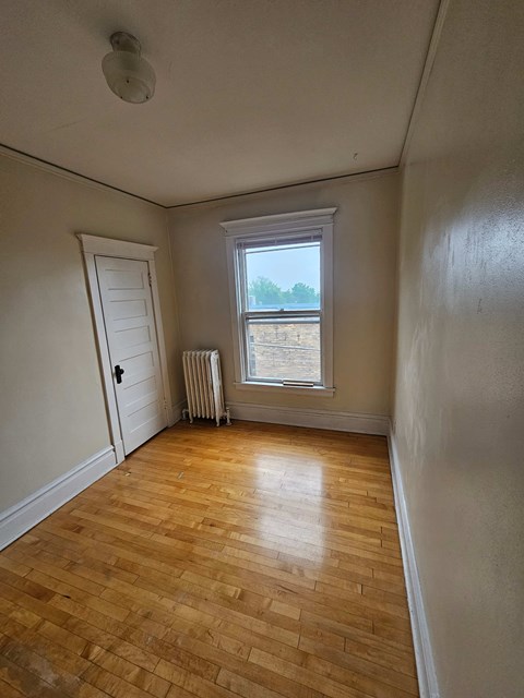 A room with a wooden floor and a window.