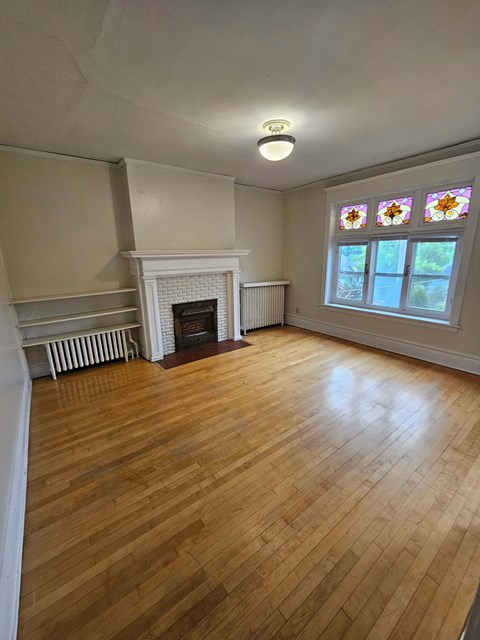 A room with a fireplace and a stained glass window.