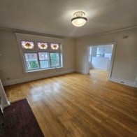 A room with a window and wooden floors.