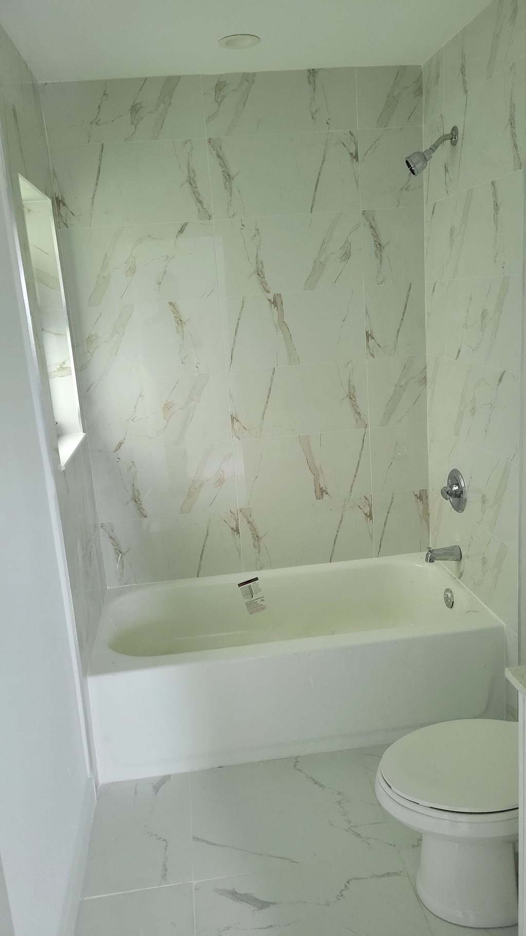 a white bathroom with a tub and a toilet