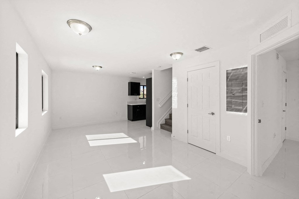 a large white room with white tiles and a white door