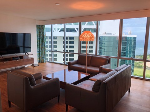 A living room with brown leather furniture and a flat screen TV.