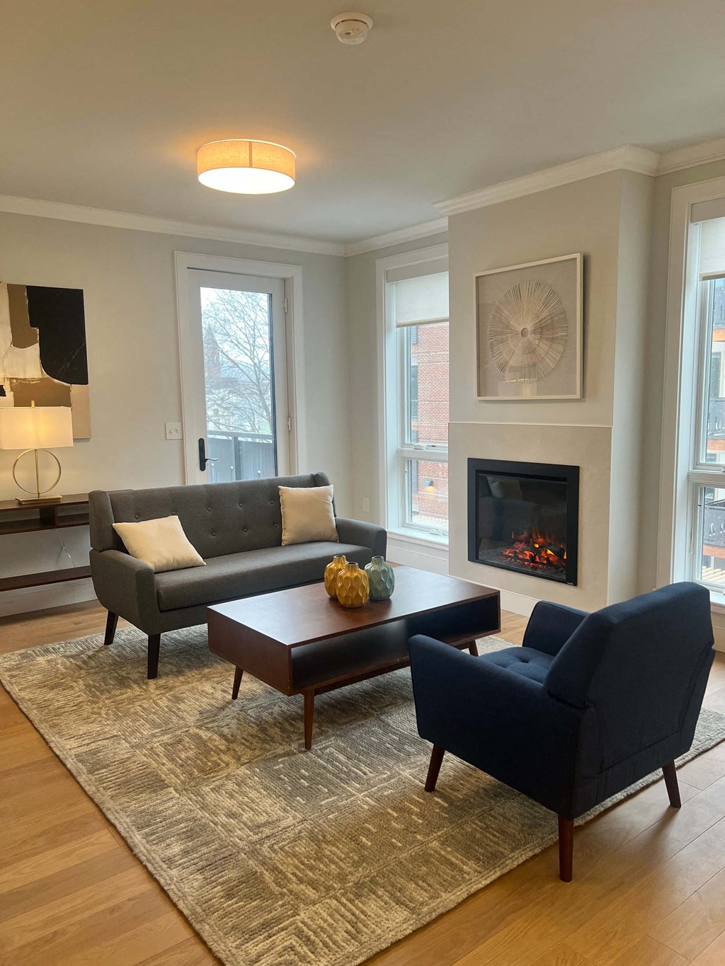 a living room with a couch and two chairs in front of a fireplace