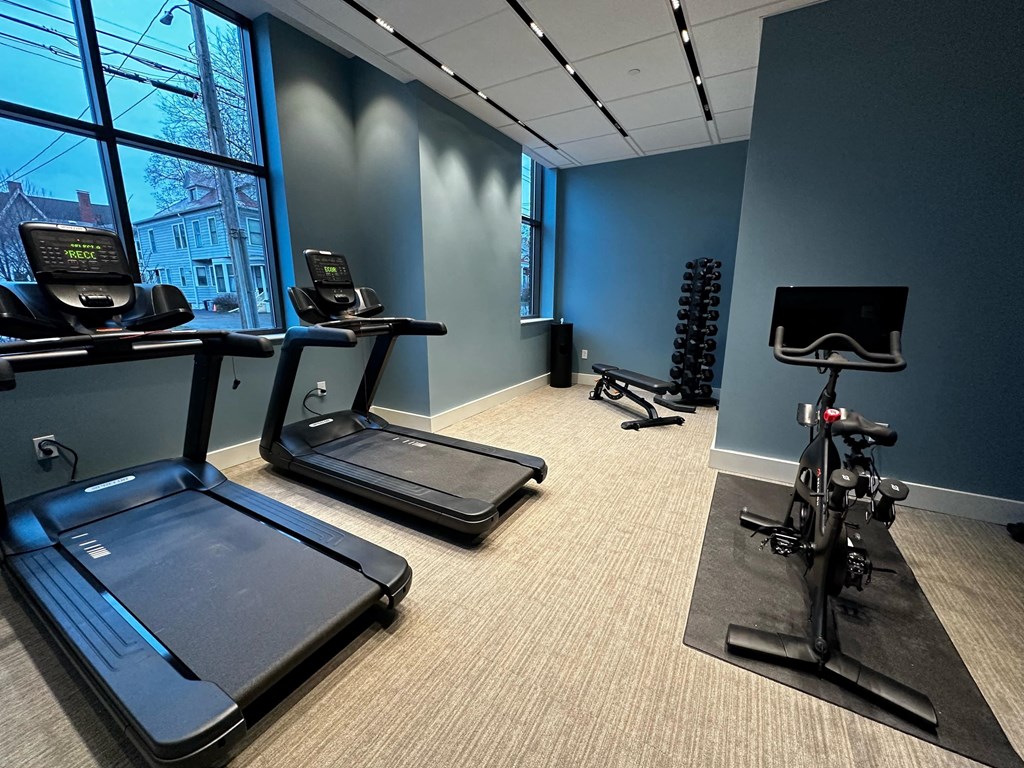 a fitness room with treadmills and exercise equipment