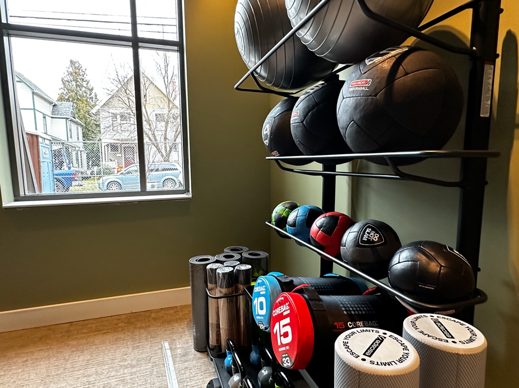 a workout room with weights and dumbbells and a window
