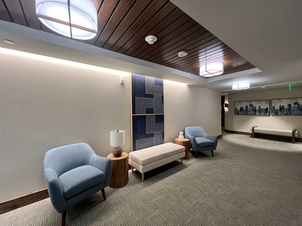 a lobby with chairs and tables and a wall mural