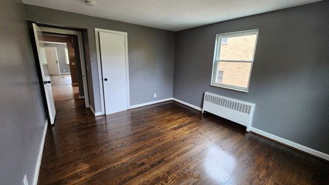 an empty living room with wooden floors and a window